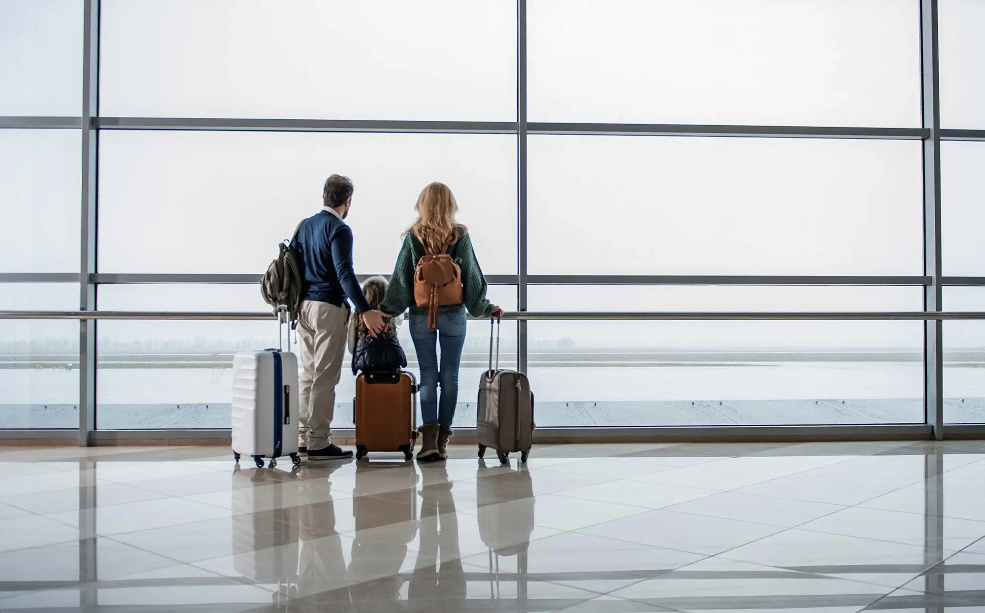 Family with suitcases preparing to get on flight