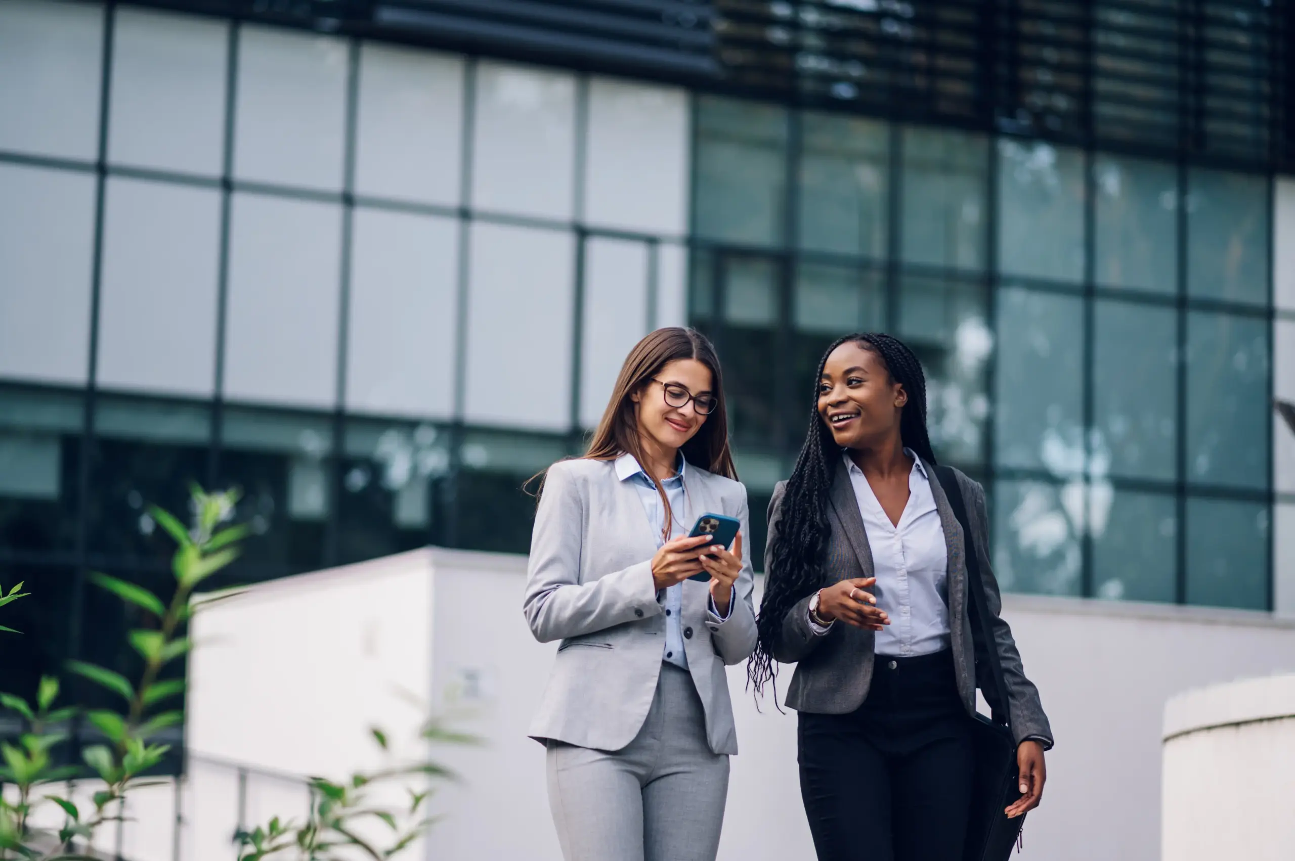 Women outside high rise office on phone